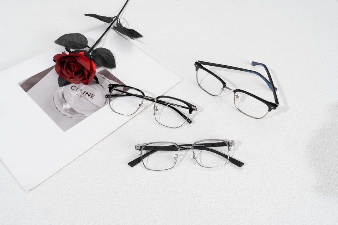 Elegant collection of designer eyewear frames displayed alongside a red rose